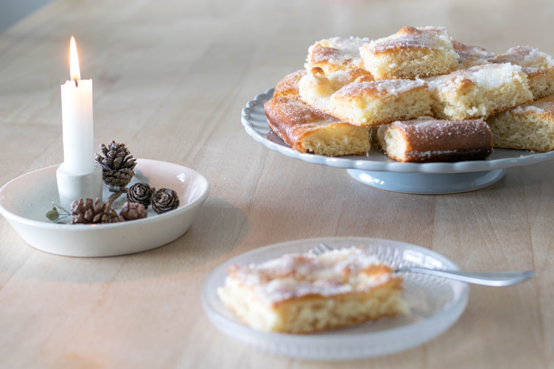 a table topped with a plate of cake next to a candle