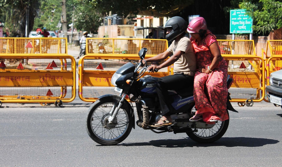a man and woman riding on the back of a motorcycle