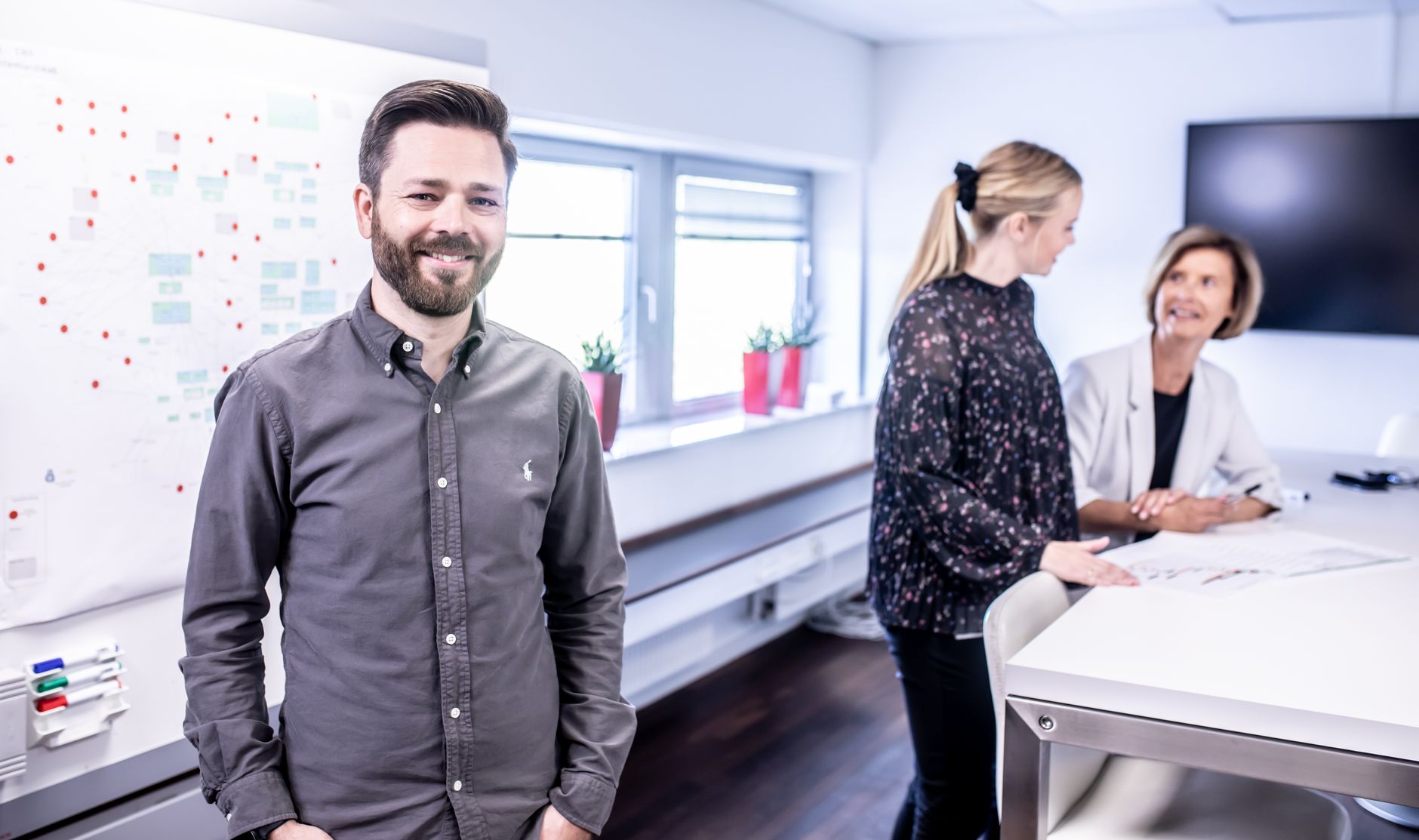 Smiling team meeting in office space with collaborative atmosphere and modern interior.