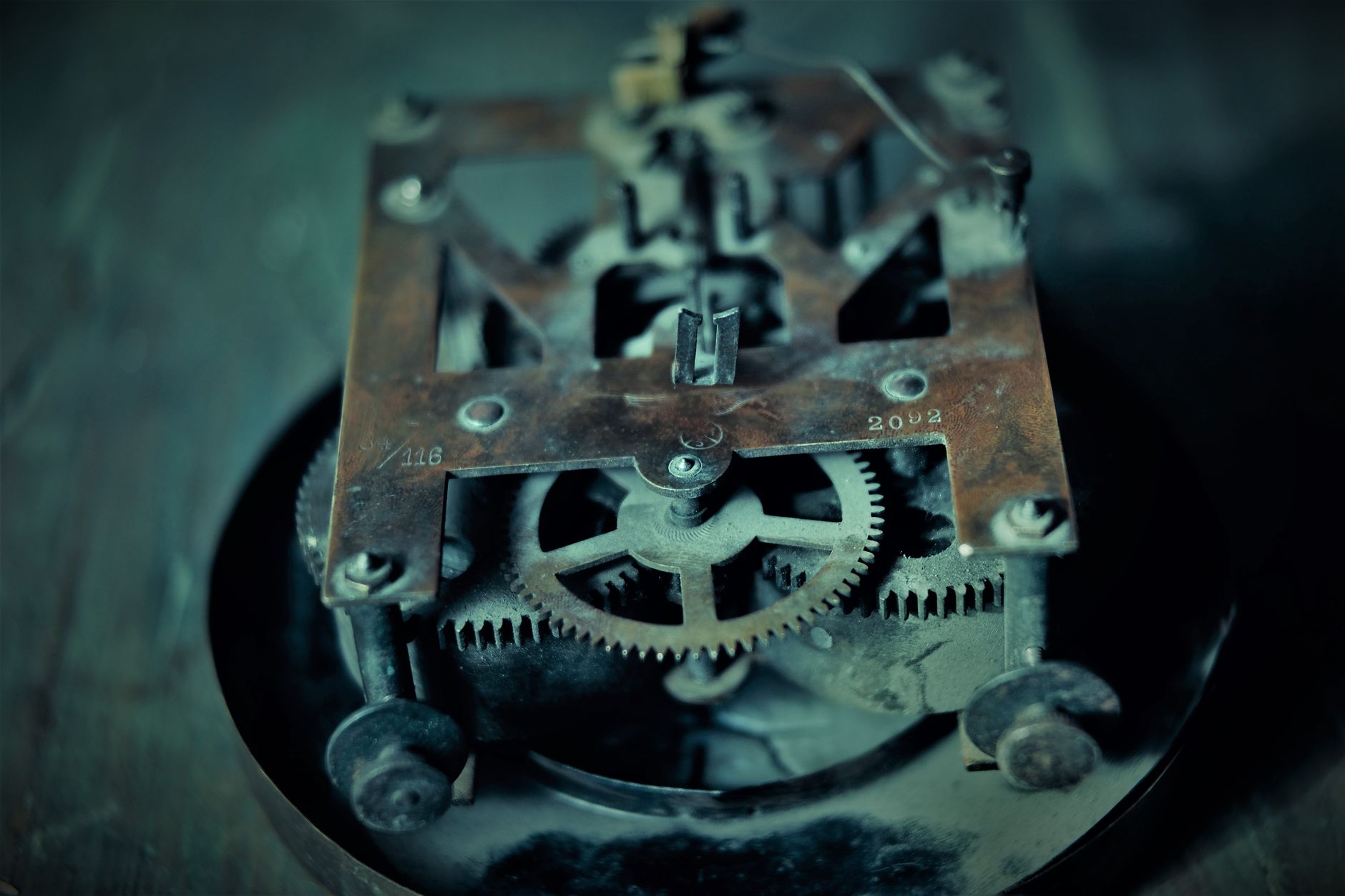 Close-up photo of an old rusty clock mechanism showcasing intricate gears and machinery.