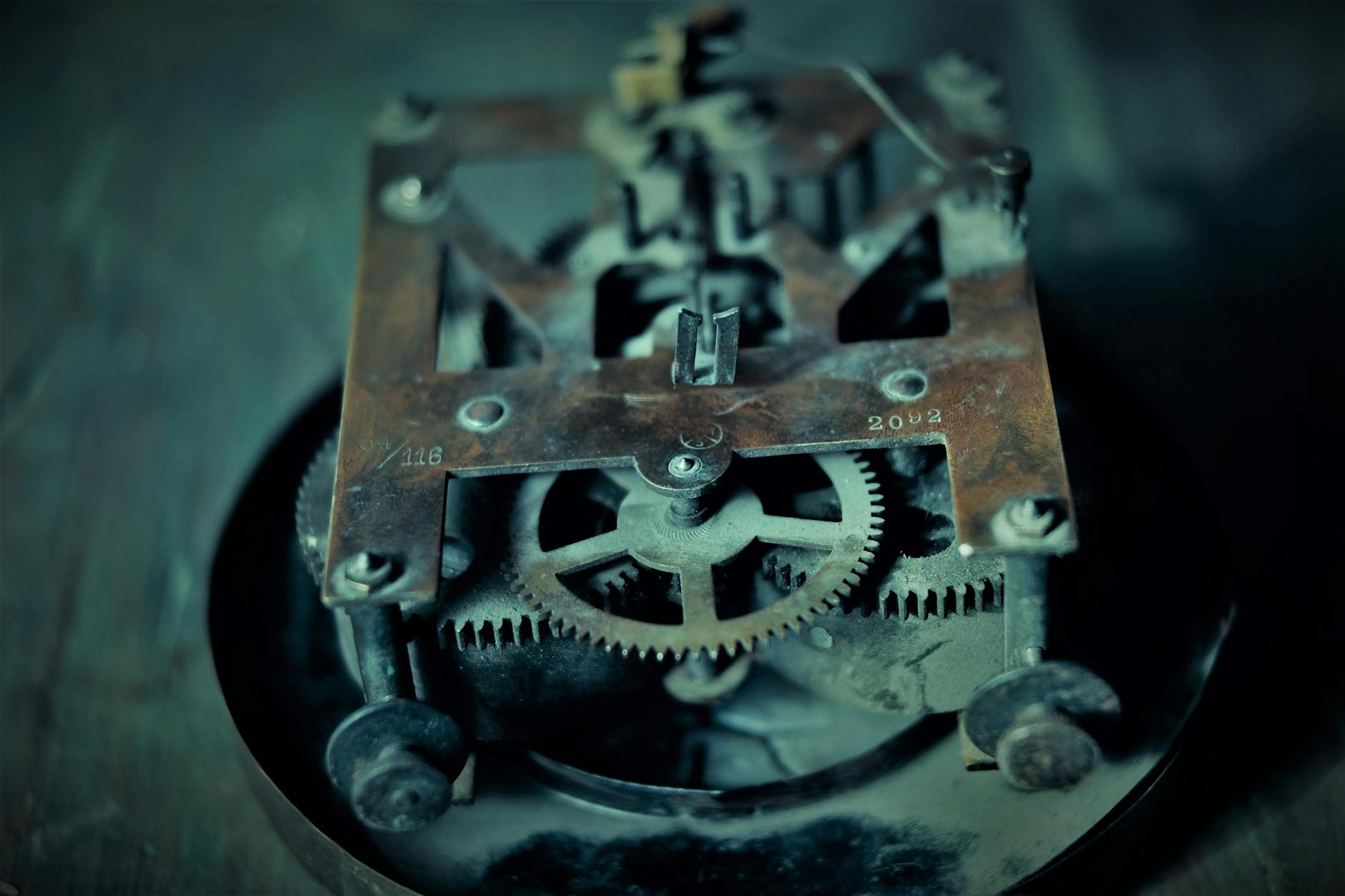 Close-up photo of an old rusty clock mechanism showcasing intricate gears and machinery.