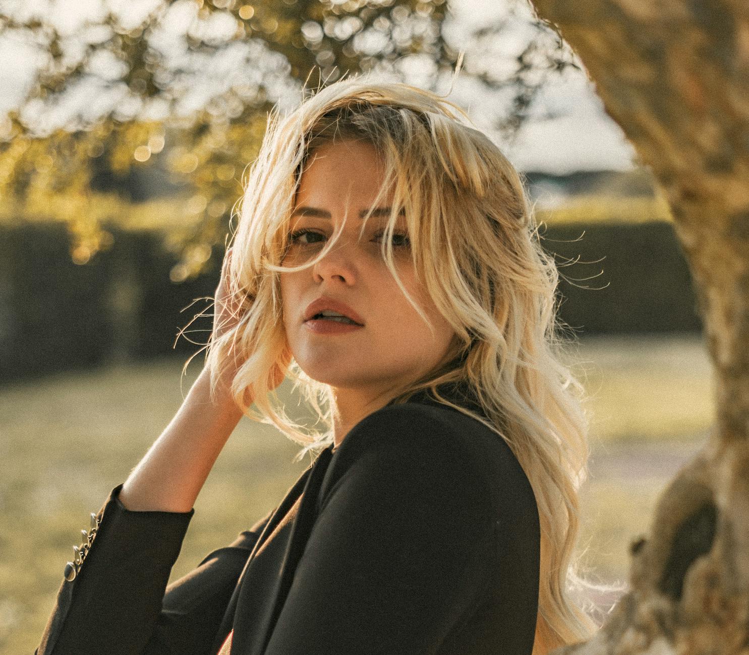 Elegant portrait of a blonde woman outdoors, capturing the warm natural beauty in Rome.