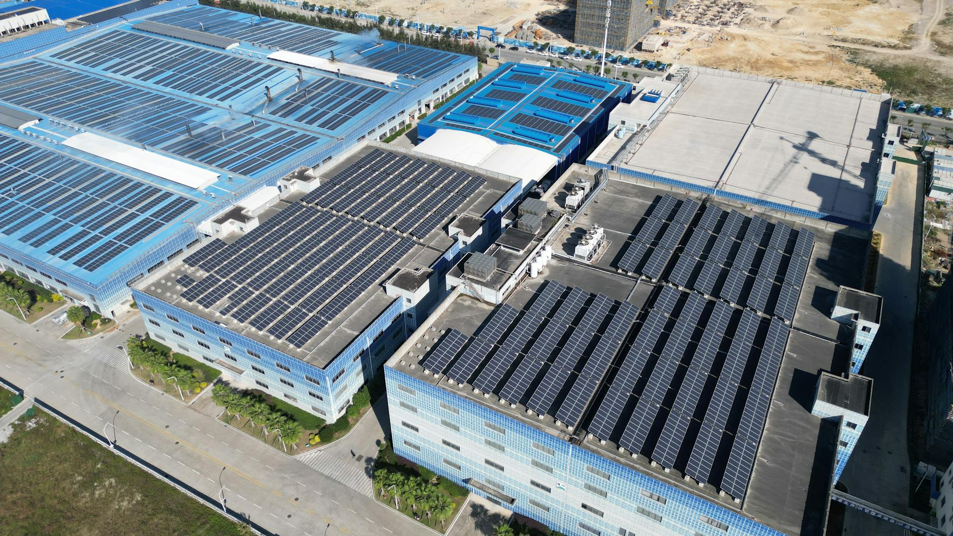 Aerial shot of industrial buildings with solar panels harnessing renewable energy.
