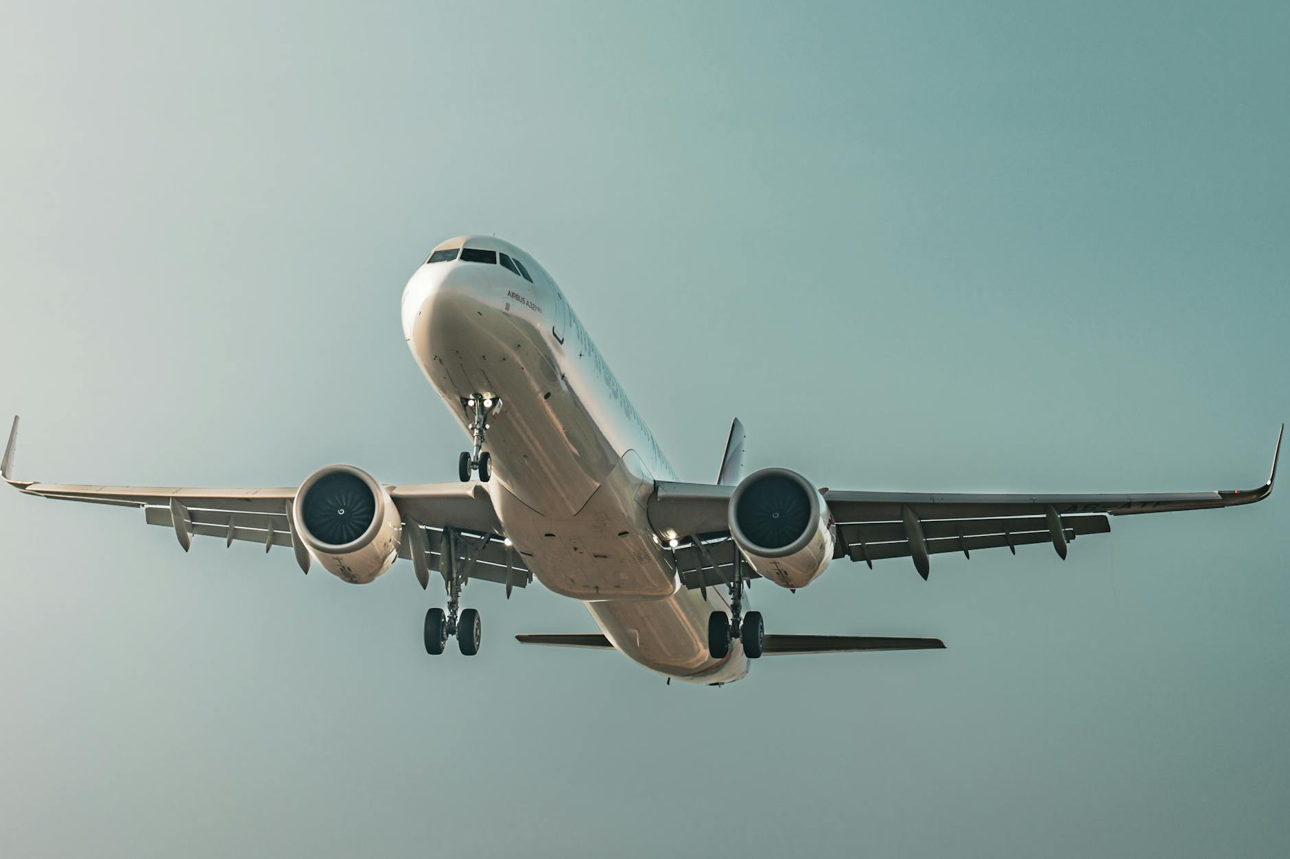 A commercial airplane takes off, soaring through a clear blue sky, showcasing its aerodynamic design.