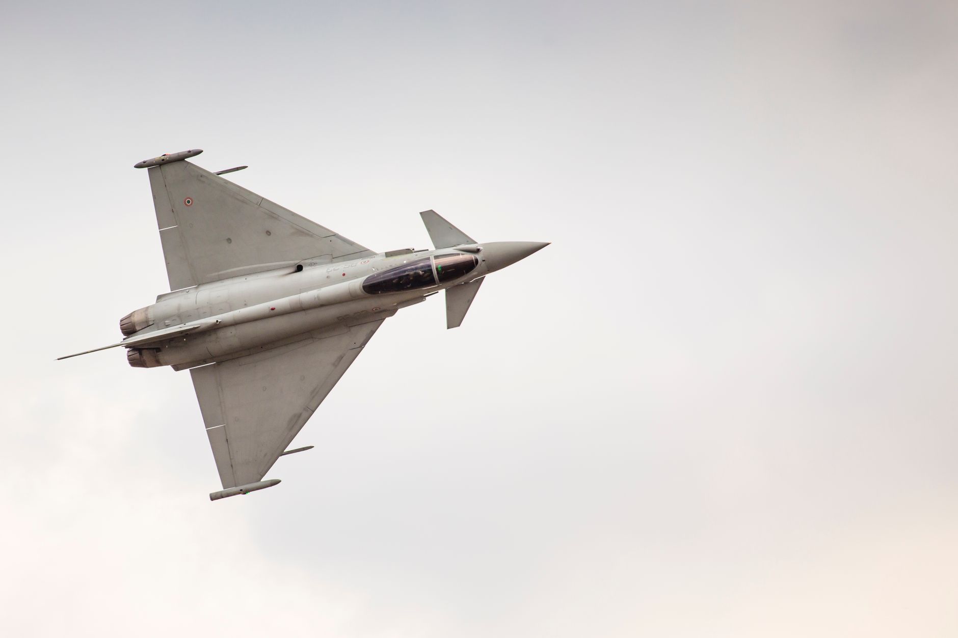 Fighter jet soaring through the sky showcasing agility and speed during an airshow performance.