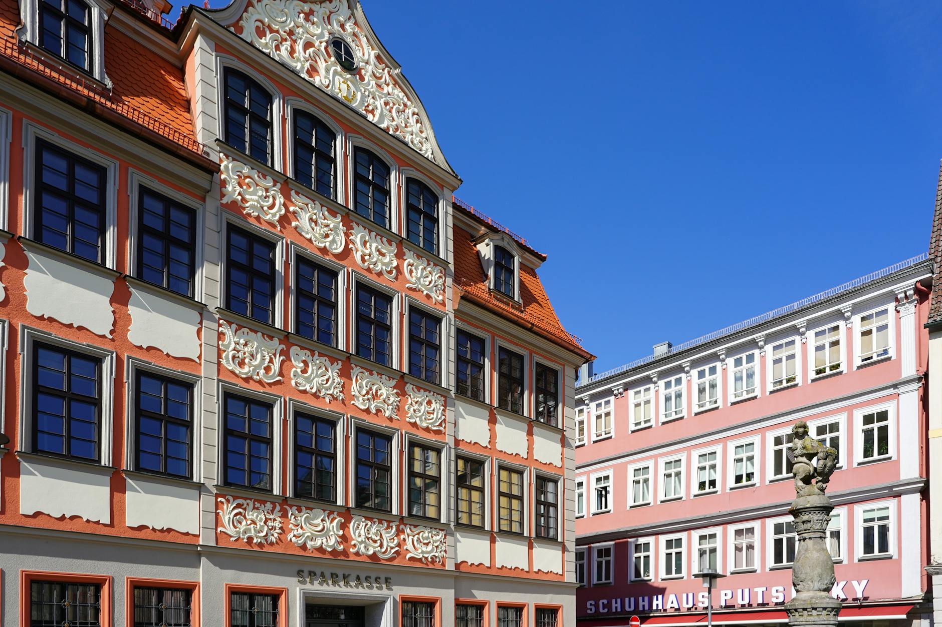 Ornate architectural facades in Coburg, Germany's historic market square on a sunny day.
