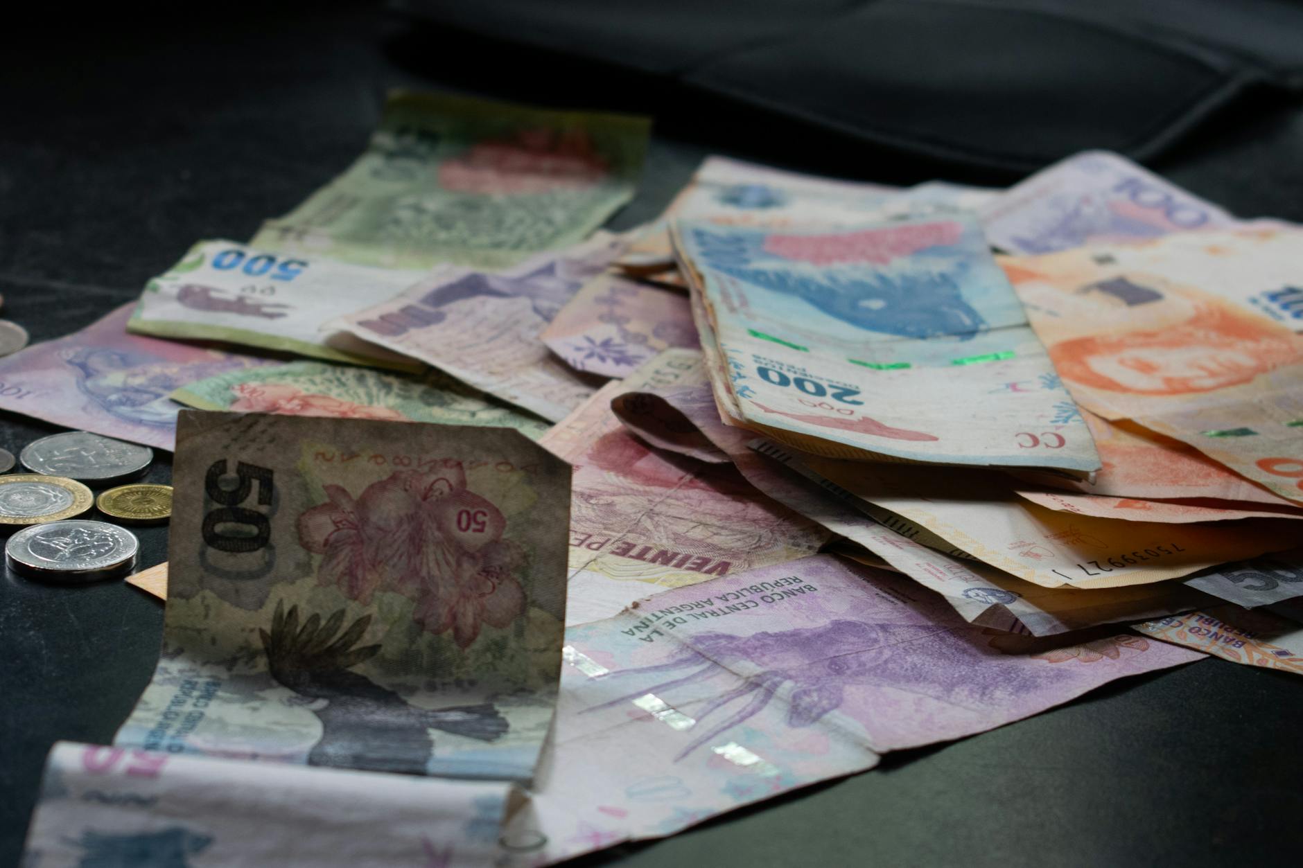 A mix of international banknotes and coins displayed on a table, highlighting diverse world currencies.