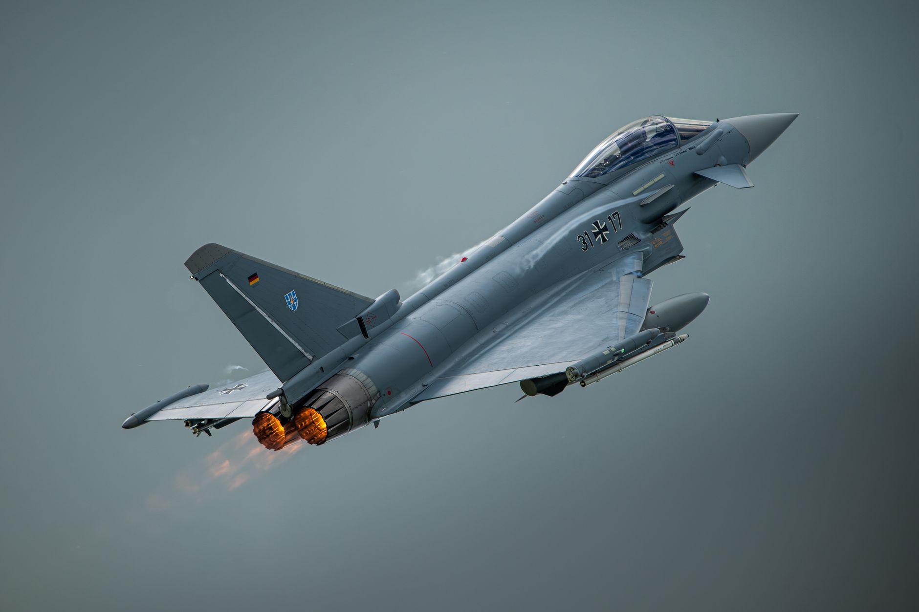 Dramatic image of a Eurofighter Typhoon with afterburners engaged during a flight maneuver.