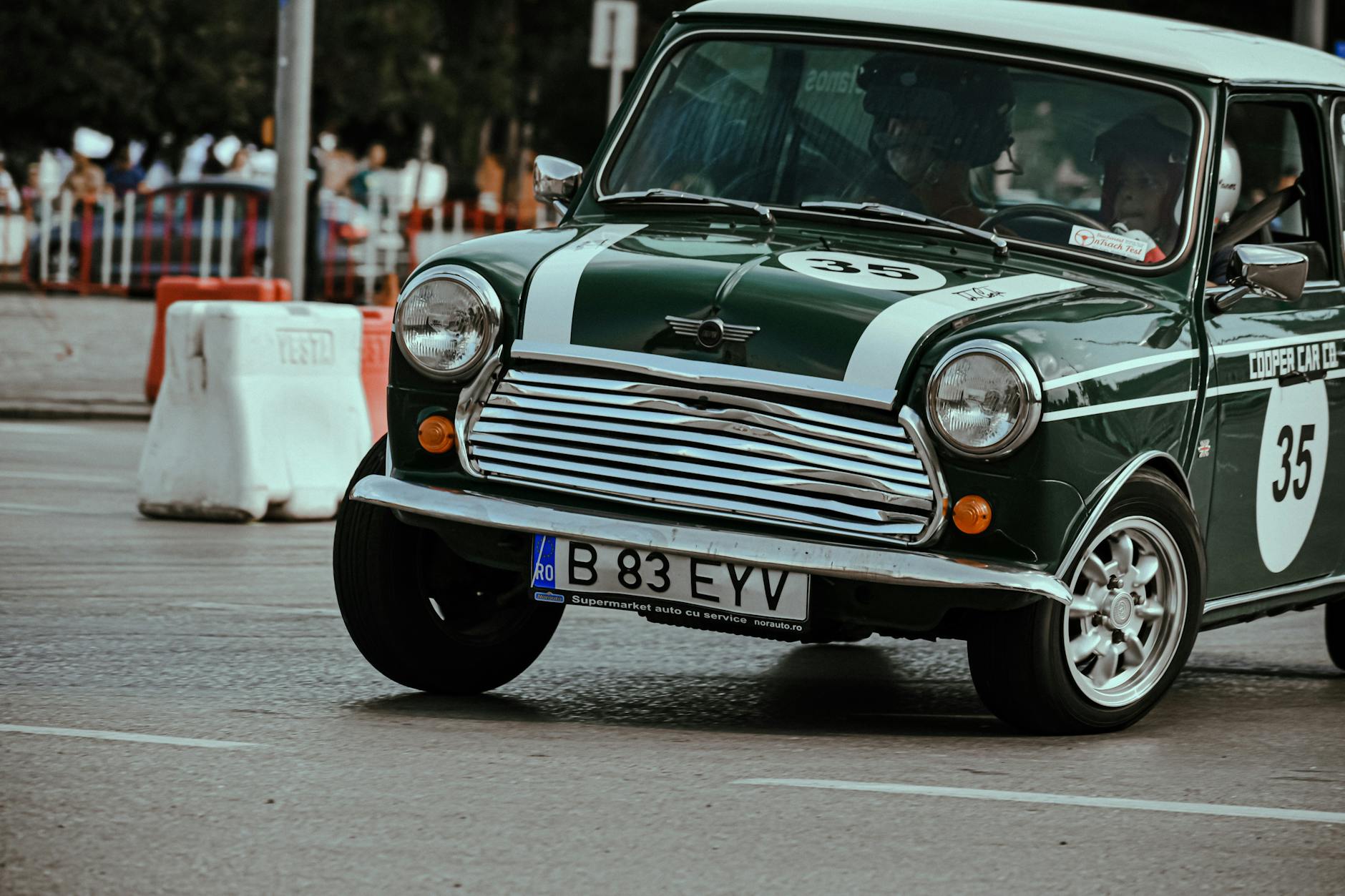 Black retro car driving fast in turn on asphalt roadway taking part in urban races