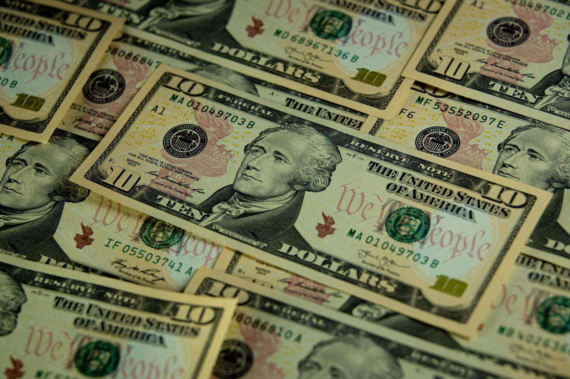 A detailed close-up of overlapping ten dollar bills showcasing American currency.