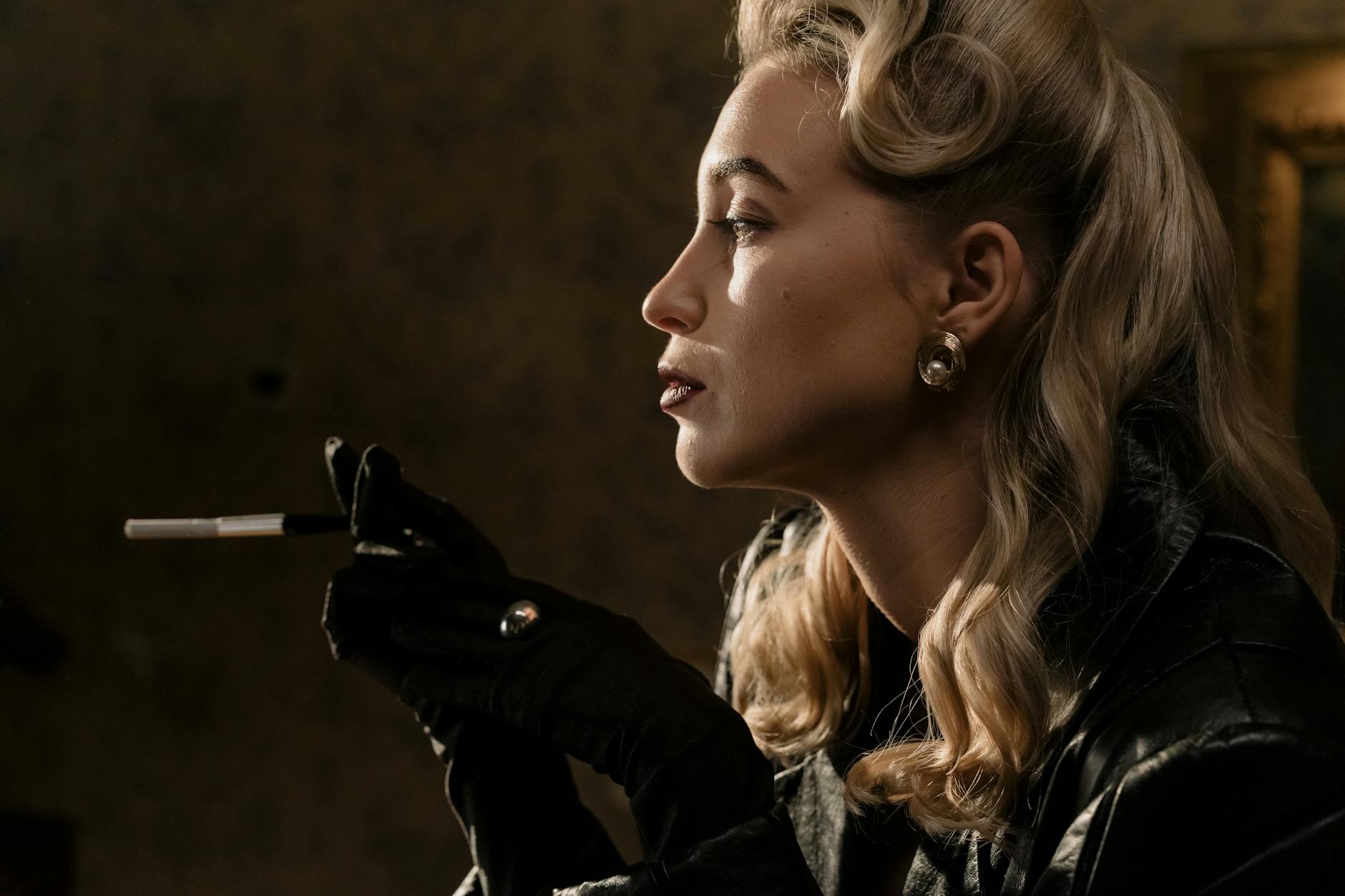Glamorous vintage portrait of a woman with blonde curls smoking in noir style.