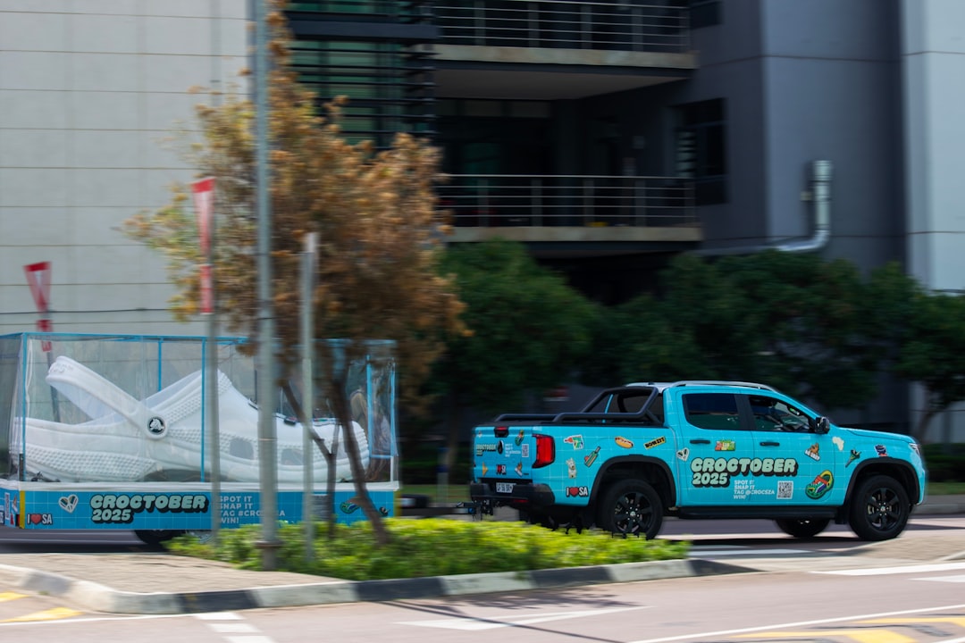 Blue truck towing a large white shoe on a trailer